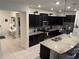 Open kitchen with black cabinetry, granite countertops, stainless steel appliances, and a breakfast bar at 197 Jetty Way, Davenport, FL 33897
