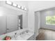 Clean, simple bathroom with decorative vanity, sink and bright lighting looking towards bedroom at 2065 East Pkwy, Deland, FL 32724
