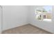 A cozy bedroom with neutral carpet, a window with bright outside view, and white walls at 2065 East Pkwy, Deland, FL 32724