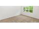 Bright bedroom features neutral carpet, base trim, and a large window overlooking a lush, green landscape at 2065 East Pkwy, Deland, FL 32724