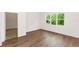 Well-lit bedroom with wood-look flooring and a large window overlooking lush greenery and neutral paint at 2065 East Pkwy, Deland, FL 32724