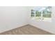 Bright bedroom features plush carpet, natural light from a large window, and neutral paint at 2065 East Pkwy, Deland, FL 32724