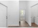 Hallway with wood floors, white walls, leading to bedroom with window view and laundry area at 2065 East Pkwy, Deland, FL 32724