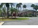 Exterior view of the community clubhouse with palm trees, manicured landscaping, and brick accents at 207 Esplanade Way # 101, Casselberry, FL 32707