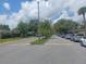 A tree-lined street with parked cars, lush landscaping, and well-maintained homes on a sunny day at 207 Esplanade Way # 101, Casselberry, FL 32707