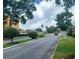 Residential street view showcasing neatly trimmed bushes, a red car, and mature shade trees at 207 Esplanade Way # 101, Casselberry, FL 32707