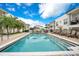 Resort-style community pool with inviting lounge chairs, umbrellas, and surrounding lush landscaping at 2305 Edgewater Dr # 1604, Orlando, FL 32804