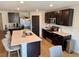 A modern kitchen featuring a large island with counter seating and sleek, dark cabinetry and stainless steel appliances at 239 Se 66Th Ct, Ocala, FL 34472