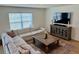 Bright and airy living room with a large sectional sofa, decorative rug, and modern entertainment center at 239 Se 66Th Ct, Ocala, FL 34472