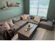 Comfortable living room features a large sectional couch, a wooden coffee table and decor shelf at 239 Se 66Th Ct, Ocala, FL 34472