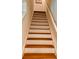 Wooden stairway featuring white risers and handrail, offering a clear path to the upper level at 239 Se 66Th Ct, Ocala, FL 34472