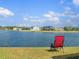 Relaxing backyard lake view, featuring a chair and a picturesque waterfront setting on a sunny day at 2803 Boating Blvd, Kissimmee, FL 34746