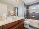 Well-lit bathroom featuring a dark wood vanity and a shower-tub combo with tiled walls at 2803 Boating Blvd, Kissimmee, FL 34746