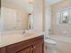 Well-lit bathroom featuring a vanity with sink, toilet, and a shower-tub combination at 2803 Boating Blvd, Kissimmee, FL 34746
