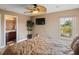 Comfortable bedroom featuring wood-look floors, a ceiling fan, tv, and an attached bathroom at 2803 Boating Blvd, Kissimmee, FL 34746