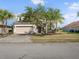 Inviting front exterior featuring a well-maintained lawn, landscaping, and a two-car garage at 2803 Boating Blvd, Kissimmee, FL 34746