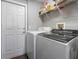 Functional laundry room with modern washer and dryer set, shelving for storage, and a door for easy access, simplifying chores at 2803 Boating Blvd, Kissimmee, FL 34746