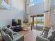 Bright living room with high ceilings, a ceiling fan, and sliding glass doors leading to the pool area at 2803 Boating Blvd, Kissimmee, FL 34746