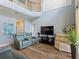 Open living room showcasing soaring ceilings, wood floors, an upper level loft and comfortable seating, perfect for modern living at 2803 Boating Blvd, Kissimmee, FL 34746