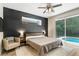 Comfortable bedroom featuring a dark accent wall, neutral decor, and access to the screened-in pool area at 2906 Sunset Vista Ct, Kissimmee, FL 34747