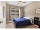 Bright bedroom with wood-look floors, ceiling fan, and a large window for natural light at 2906 Sunset Vista Ct, Kissimmee, FL 34747