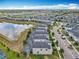 Aerial view of a community featuring lush landscaping, a lake, and private screened in pools at 303 Ocean Course Ave, Davenport, FL 33896