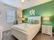 Bedroom with green accent wall, ceiling fan, window, and bedside tables at 303 Ocean Course Ave, Davenport, FL 33896