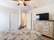 Bedroom featuring dresser, TV, ceiling fan, and neutral color scheme at 303 Ocean Course Ave, Davenport, FL 33896