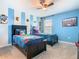 Vibrant ' bedroom featuring twin beds with unique accent walls and ceiling fan at 303 Ocean Course Ave, Davenport, FL 33896