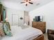 Bright bedroom features a ceiling fan, a TV, and a cozy bed with decorative pillows and throws at 303 Ocean Course Ave, Davenport, FL 33896