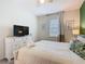 Comfortable bedroom with ceiling fan, dresser with TV, and a large window at 303 Ocean Course Ave, Davenport, FL 33896