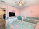 Cheerful ' bedroom with twin beds, soft pink walls, and a ceiling fan at 303 Ocean Course Ave, Davenport, FL 33896