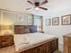 Comfortable bedroom with a wooden bed frame, ceiling fan, and decorative wall art at 303 Ocean Course Ave, Davenport, FL 33896