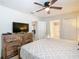 Bedroom with ceiling fan, dresser, and a comfortable bed provides a peaceful retreat at 303 Ocean Course Ave, Davenport, FL 33896