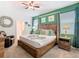 Well-lit bedroom features a cozy bed, ceiling fan, nightstands, and stylish decor for a relaxing retreat at 303 Ocean Course Ave, Davenport, FL 33896