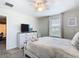 Relaxing bedroom with a dresser, neutral color scheme, ceiling fan, and bright windows at 303 Ocean Course Ave, Davenport, FL 33896