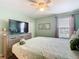 Bedroom featuring ceiling fan, TV, dresser, window, and comfortable bed for a relaxing and cozy space at 303 Ocean Course Ave, Davenport, FL 33896