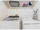 Clean laundry room featuring modern washer and dryer units and ample shelving space at 303 Ocean Course Ave, Davenport, FL 33896