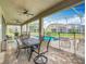 Outdoor patio with dining and seating area overlooking a screened in pool and green backyard at 303 Ocean Course Ave, Davenport, FL 33896