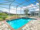 Sparkling pool and spa surrounded by a screened enclosure and brick paver patio at 303 Ocean Course Ave, Davenport, FL 33896