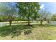 Backyard view featuring mature trees and a white fence bordering a peaceful pond at 3752 Cleary Way, Orlando, FL 32828