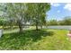 Backyard with mature trees, a white fence, and a tranquil pond view at 3752 Cleary Way, Orlando, FL 32828