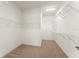 Walk-in closet featuring carpeted floors and custom shelving for organization and ample storage space at 3752 Cleary Way, Orlando, FL 32828