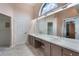 Bright bathroom featuring double sinks, large mirror, and two closets at 3780 Ventura Cove Dr, Orlando, FL 32822