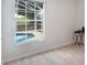 Bright bedroom with neutral walls and wood floor overlooking the screened-in pool at 3780 Ventura Cove Dr, Orlando, FL 32822