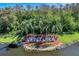 Community entrance sign spelling VENTURA and enhanced by vibrant landscaping, mature palms, and lake views at 3780 Ventura Cove Dr, Orlando, FL 32822