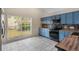 Bright kitchen features blue cabinets, stainless steel appliances, tile backsplash, and a large window view at 3780 Ventura Cove Dr, Orlando, FL 32822