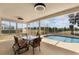 Enclosed lanai with a glass top table, four chairs, and an inviting view of the pool at 3780 Ventura Cove Dr, Orlando, FL 32822