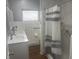 Well-lit bathroom with dual sinks, tile walls, and a shower with a striped curtain at 404 E Kentucky Ave, Deland, FL 32724