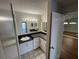 Bathroom featuring a sink, drawers, a mirrored wall and a doorway to the living room at 4109 Fairview Vista Pt # 315, Orlando, FL 32804